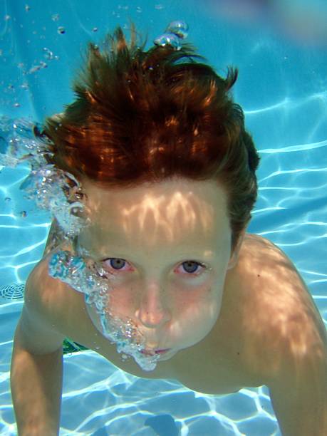 istock Boy Swimming Underwater Blowing Bubbles With Irritated Chlorine Eyes 165652293