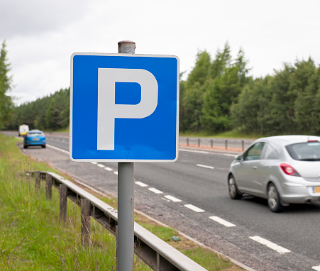 A 'P' sign denoting a layby, with a car stopped for a break on a British dual carriageway.  