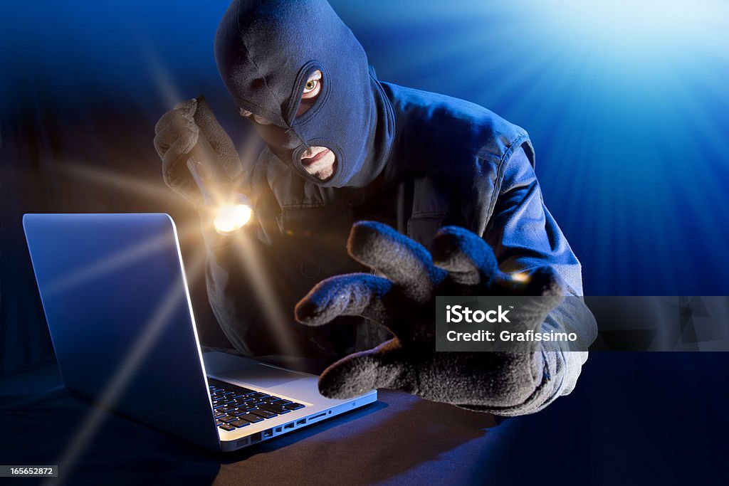 Ladro di rubare i dati dal computer portatile DVD - Foto stock royalty-free di Crimine aziendale