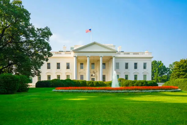 Photo of The White House, green lawn, blue sky, early morning light