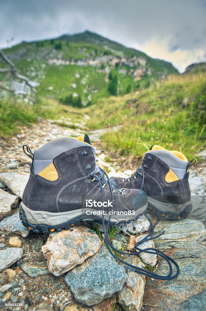 Botas de excursionismo en una ruta A las montañas, alpes - Foto de stock de Abandonado libre de derechos