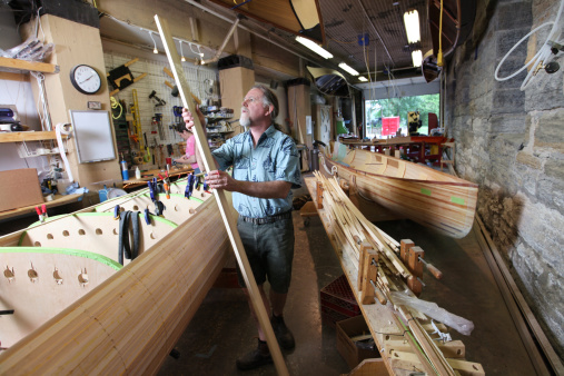 Small business owner and canoe builder in his workshop. In the process of building cedar strip canoes.