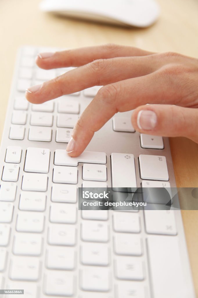 Mujer presionar el botón de devolución en un Teclado blanco - Foto de stock de Tecla Enter libre de derechos