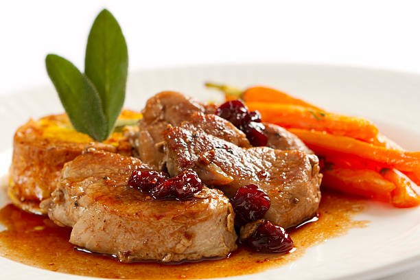 Plate full of pork loin medallions and carrots stock photo