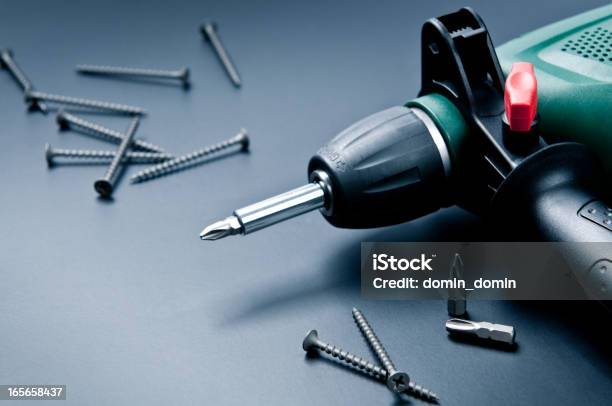 Electric Drill With Screws And Screwdrivers On Dark Background Stock Photo - Download Image Now