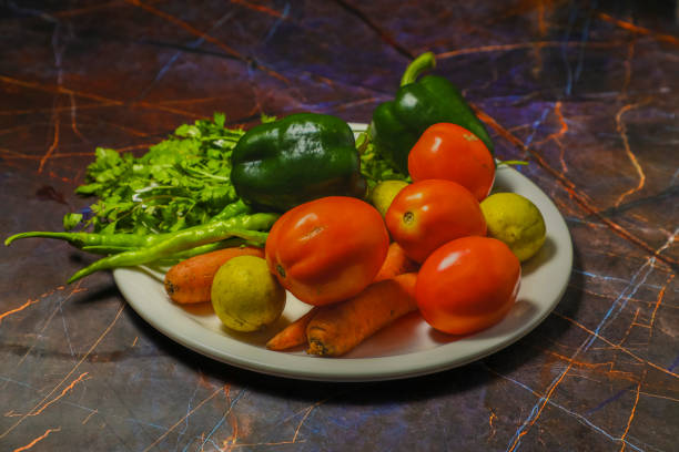 A white plate with pickled tomatoes, lemon, carrot and other vegetables