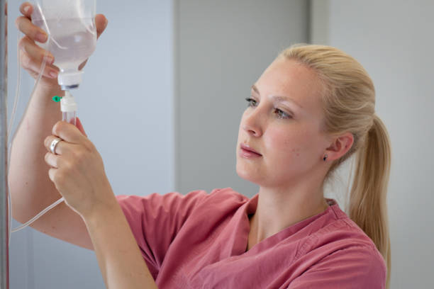 A female medical assistant is preparing an infusion medical assistant is preparing an infusion infused oil stock pictures, royalty-free photos & images