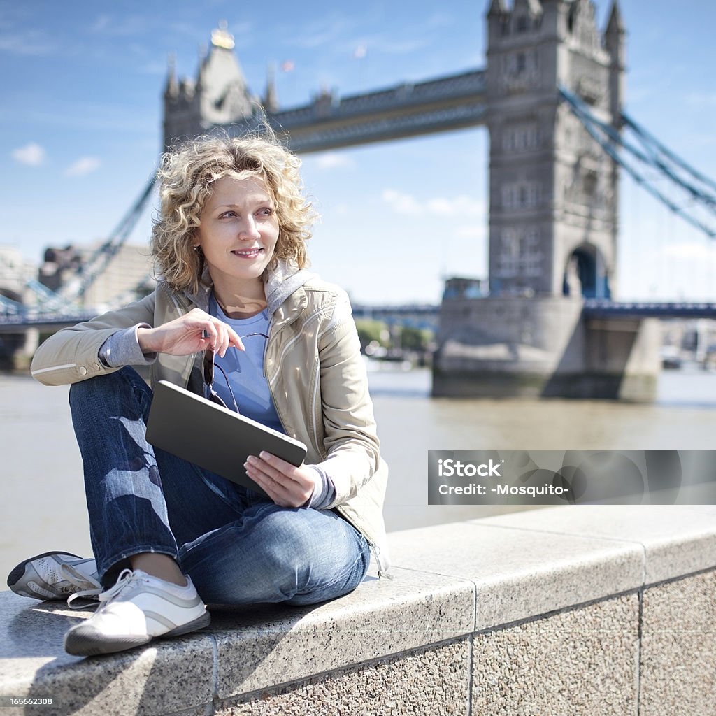 Joven hermosa mujer usando tableta Digital al aire libre - Foto de stock de Luz del sol libre de derechos