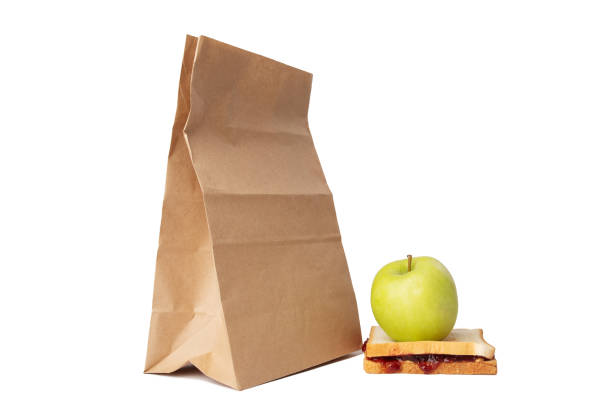 sandwich with peanut butter and raspberry jam with green apple and lunch bag isolated,classic american school lunch