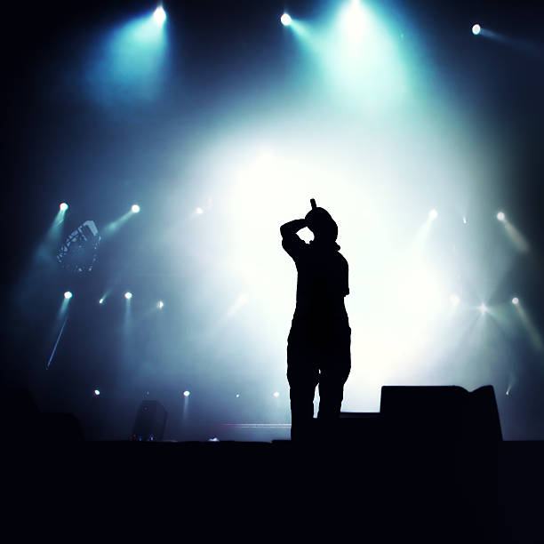Hip hop singer Silhouette of hip hop singer on stage.  rap stock pictures, royalty-free photos & images