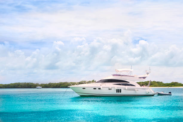 Luxury yachts anchored in a Tropical island turquoise beach. Francisqui cay. Boats, sailboats and yachts anchored in a Caribbean island. Travel and leisure related images for vacations in the Caribbean. Image taken at Los Roques, Venezuela. Los Roques is an archipelago or group of small islands located at 80 miles north of the Venezuelan coastline and a very popular destination for leisure, diving, kite surfing and all king of water activities. Los Roques and the beauty of the turquoise coastal beaches of Venezuela are almost indistinguishable from those of the Bahamas, Fiji, Bora Bora, French Polynesia, Malau, Hawaii, Cancun, Costa Rica, Florida, Maldives, Cuba, Puerto Rico, Honduras, or other tropical areas.