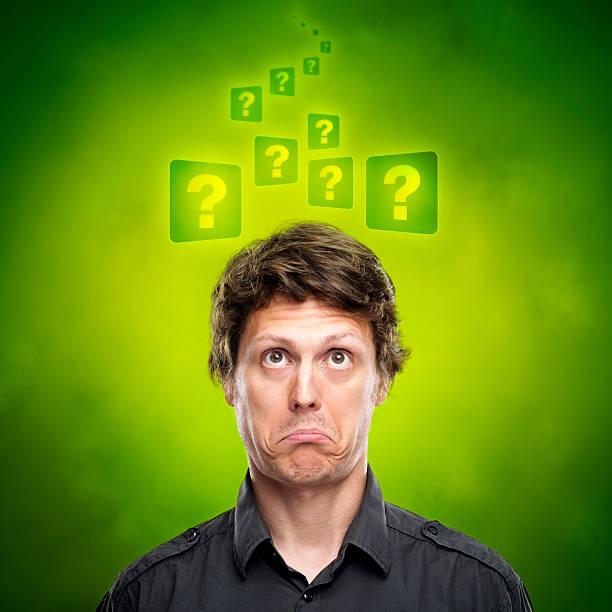 Young man surrounded with question marks cloud.