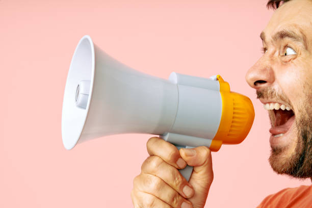 istock Funny man screaming in megaphone with copy space 1656675630