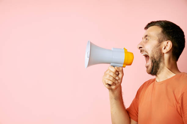 istock Funny man screaming in megaphone with copy space 1656675632