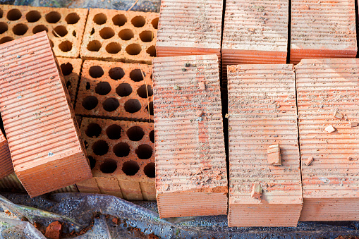 A pile of new bricks at construction site sitting on wooden flat. We have other construction images in our portfolio.