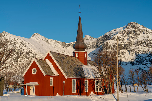 A red wooden Flakstad church in winter, on Flakstadøya island Lofoten archipelago , Nordland