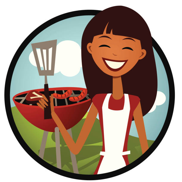 A woman in an apron holding a utensil grills food on a charcoal style bbq.
