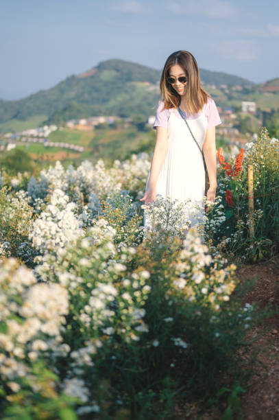A little girl walks in the garden during a visit to her grandmother in the summer. Child in a white undershirt and shorts.
