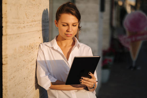 istock Portrait of woman using tablet outdoors. Female working on digital tablet 1656784583