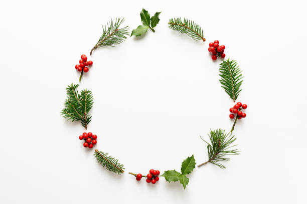 istock Christmas round frame made from holly berries and green twigs. 1656784587