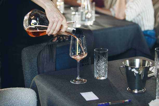 istock Sommelier pouring wine into decanter to the glasses during alcoholic beverages training for staff, close up. 1656784610
