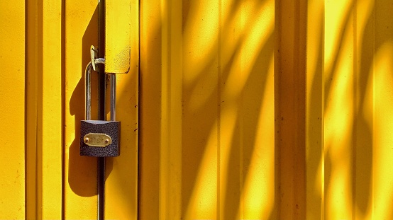 Yellow door with locked padlock