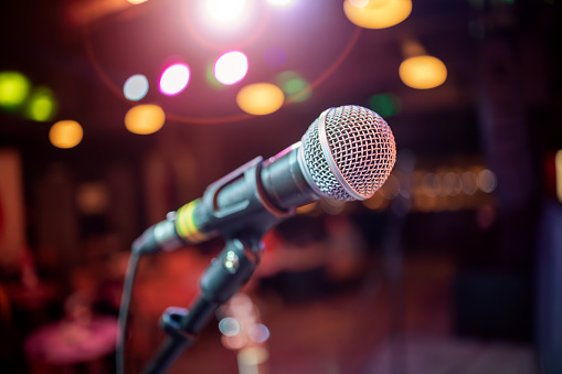 Public performance on stage Microphone on stage against a background of auditorium. Shallow depth of field.
