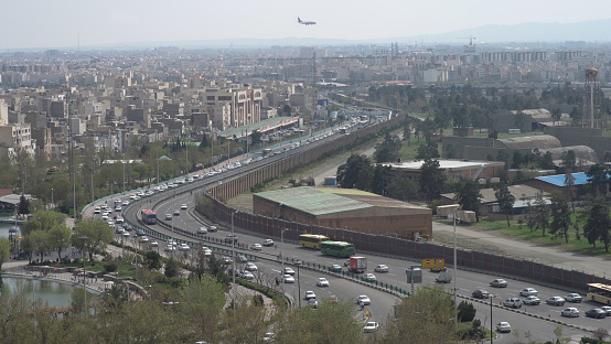 The city and streets of Tehran while a commercial airplane is landing at the Mehrabad airport
