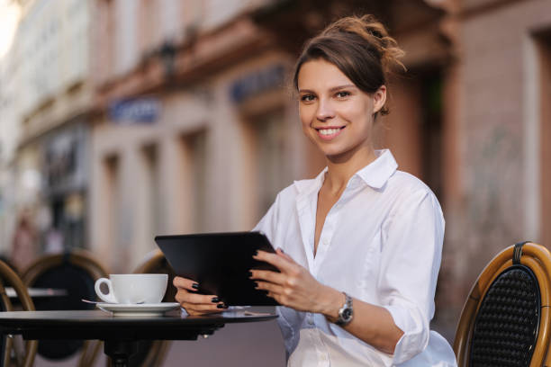 istock Portrait of attractive female freelancer using tablet in cafe on terrace 1656813112