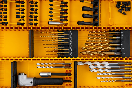 Close-up of Drill bits set professional industrial tools and equipment in yellow box.