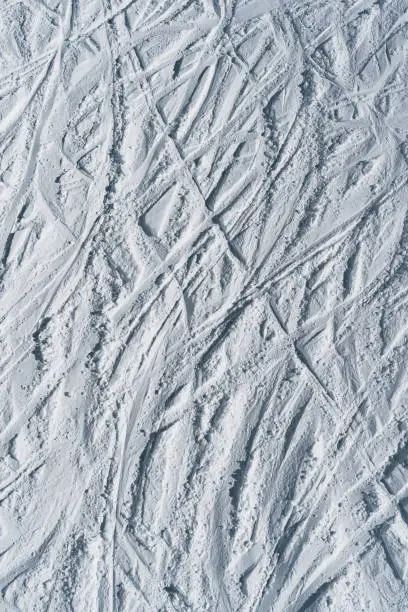 Texture de traces de ski sur une piste prise depuis un télésiège.