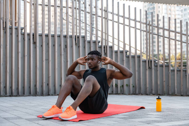 istock Confident young African man in sportswear doing sit-ups while exercising outdoors 1656865822