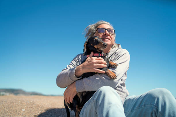 Eternal Bond: A Man Embracing His Dachshund on the Beach