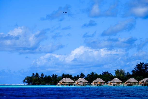 istock water with small huts and a plane in the sky over it 1656920289