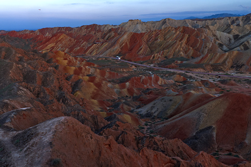 The picture showed Zhangye National GeoPark at Sunset. And the Danxia landform landscape was beautiful and colorful. If you were going to travel to Gansu, northwestern China, you should see the Danxia landform of Zhangye. In the GeoPark, you could take on bus or helicopter for sightseeing.