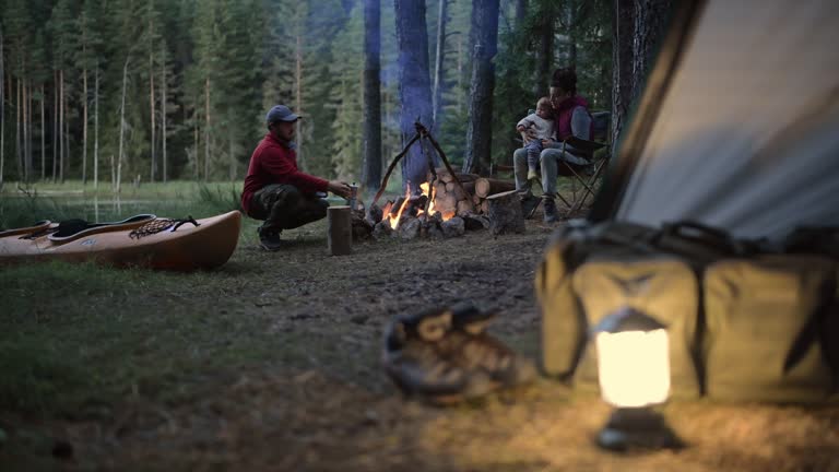 Happy family having a peaceful moment around the campfire.