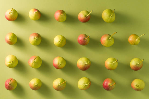 Pears pattern fruits arrangement in a row rhythm with shadows minimal flat lay green background