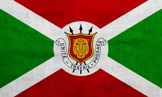 Flag and coat of arms of Republic of Burundi on a textured background. Concept collage.
