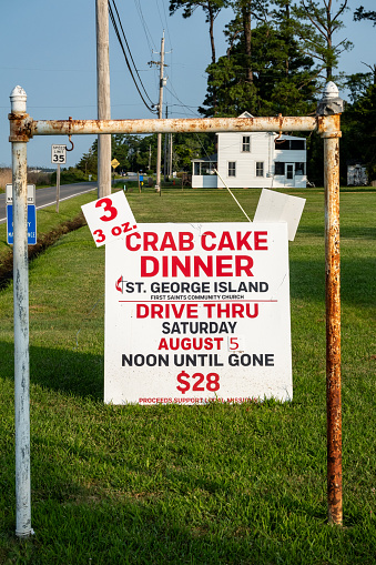 Piney Point, Maryland, USA Aug 3, 2023 A sign at a church on St George's Island offers crab cake dinners