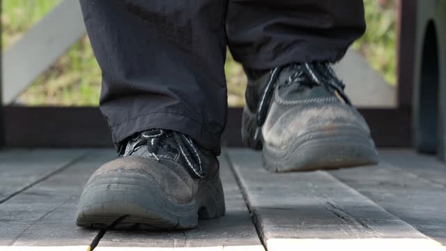close up of men feet in old worn shoes marching on the spot on the wooden flooring.