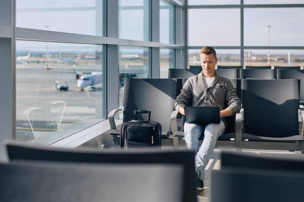 istock Man working on laptop while waiting for flight at airport 1656992188