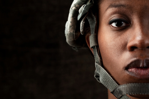 Female African American soldier in army camouflage uniform and combat headgear.