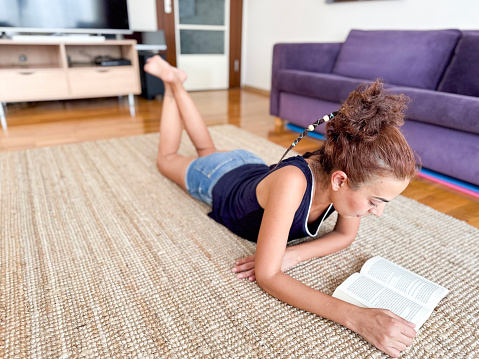 Woman reading a book on carpet