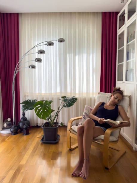 istock Woman reading a book on rocking chair 1657013045