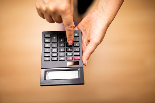 Close up hands of elderly family couple work with domestic financial papers use laptop calculator on cozy table at home office. Spouses retirees count household budget check receipts pay bills online