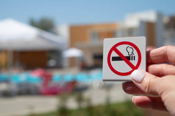 A woman's hand holds a no smoking sign. Smoking ban. stock photo