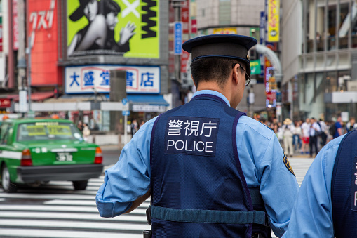Tokyo, Japan - 21 June 2023: Japanese police presence at Shibuya Crossing, known as the scramble, the busiest pedestrian crossing in the world.