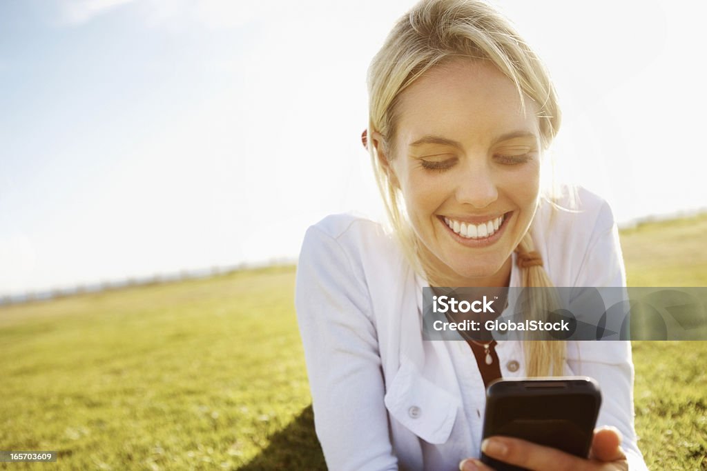 Frau liest SMS im Freien - Lizenzfrei Handy Stock-Foto
