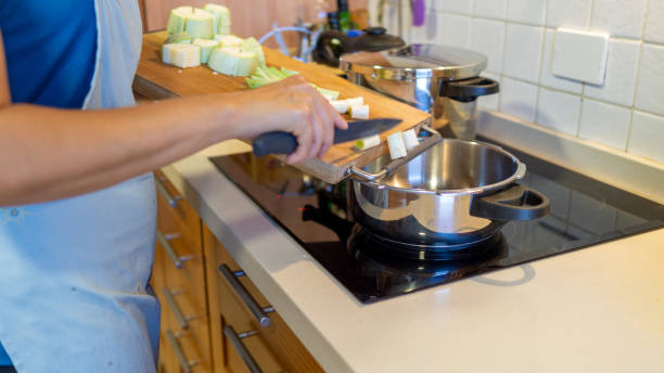 istock woman in the kitchen pouring zucchini into the pan 1657049113
