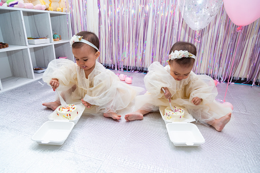 Portrait of two happy little girls looking at camera while enjoying birthday party together.